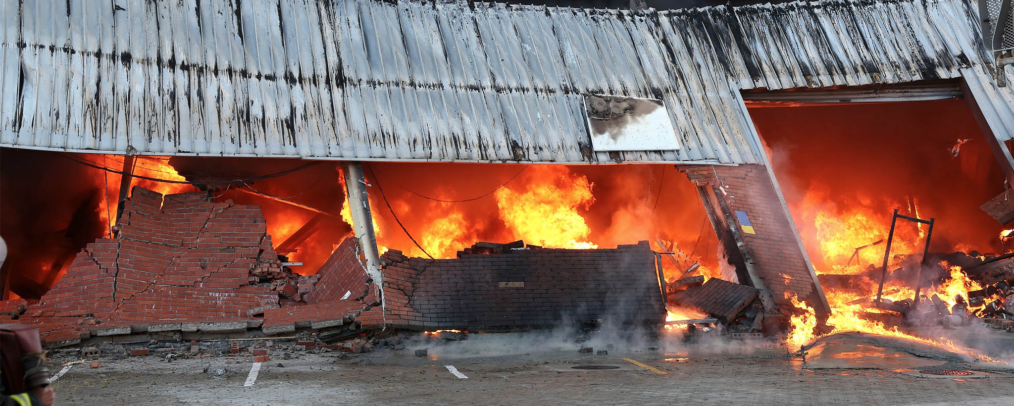 Un edificio de ladrillo se derrumba en llamas