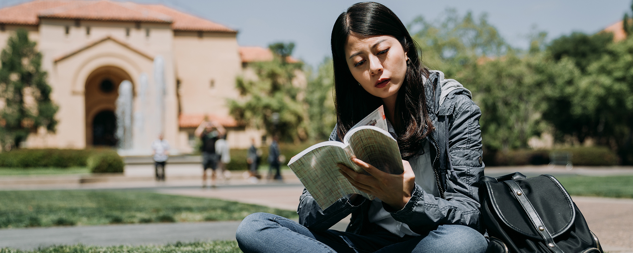 un estudiante universitario leyendo un libro en el campus