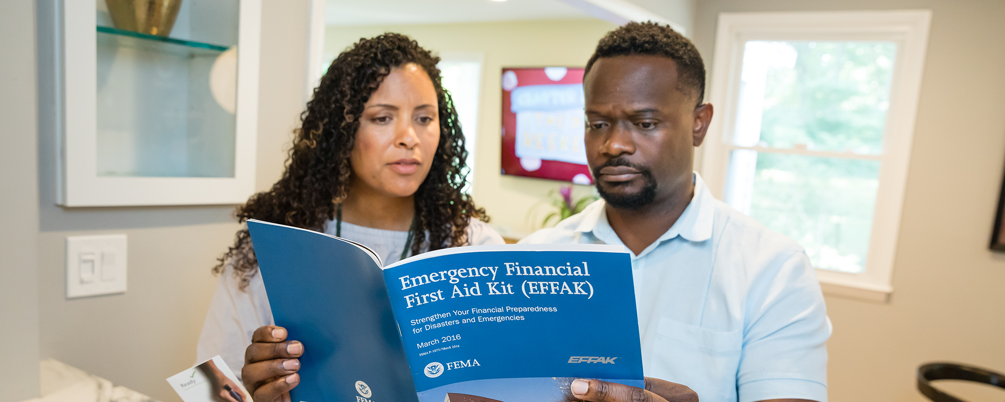 una pareja mira un botiquín de emergencia de primeros auxilios financieros