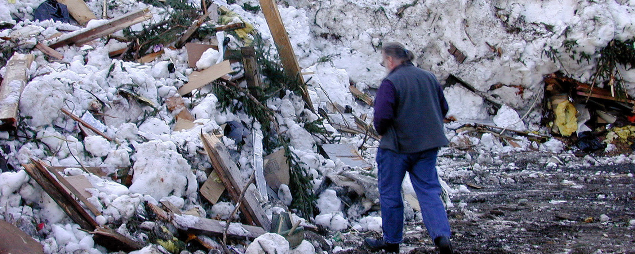 Un hombre examina el daño después de una avalancha