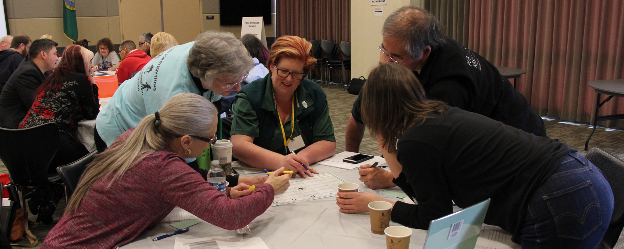 Six CERT members surrounding a table to work on an activity together