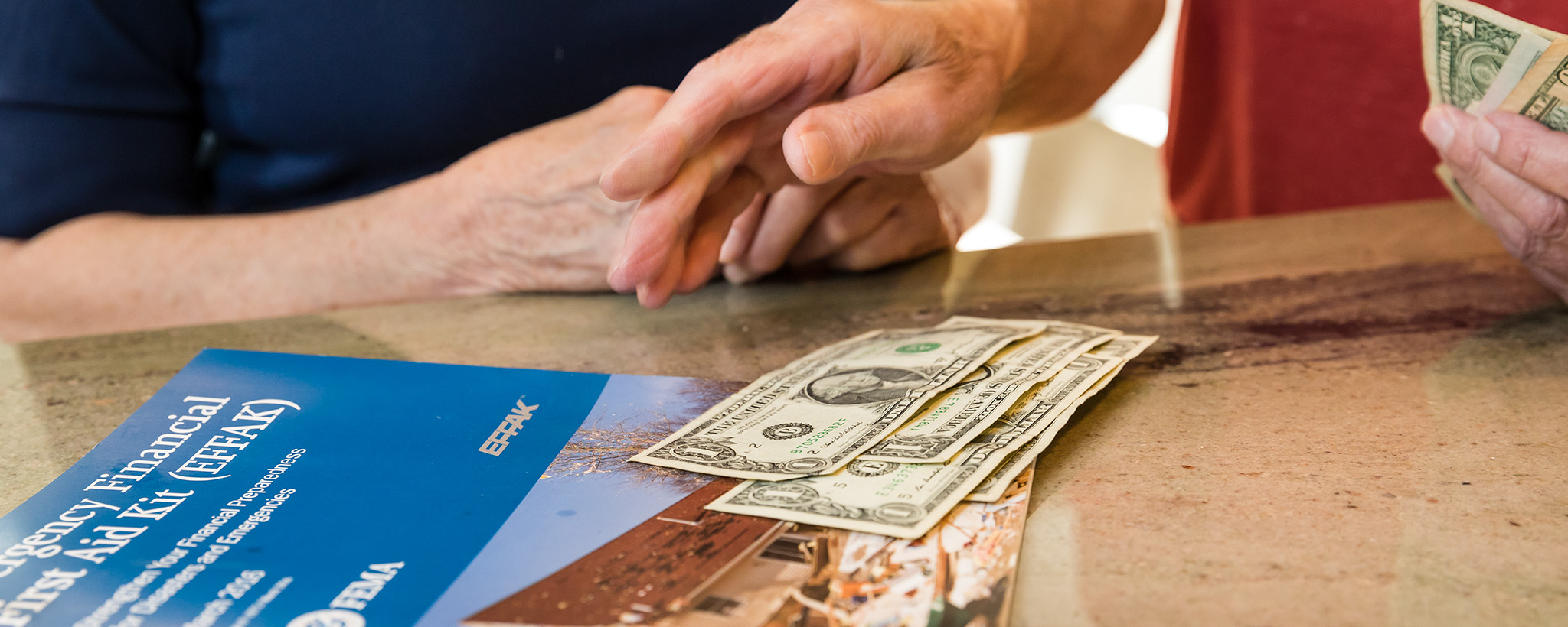 an emergency financial first aid kit and an elderly person's hands counting out money