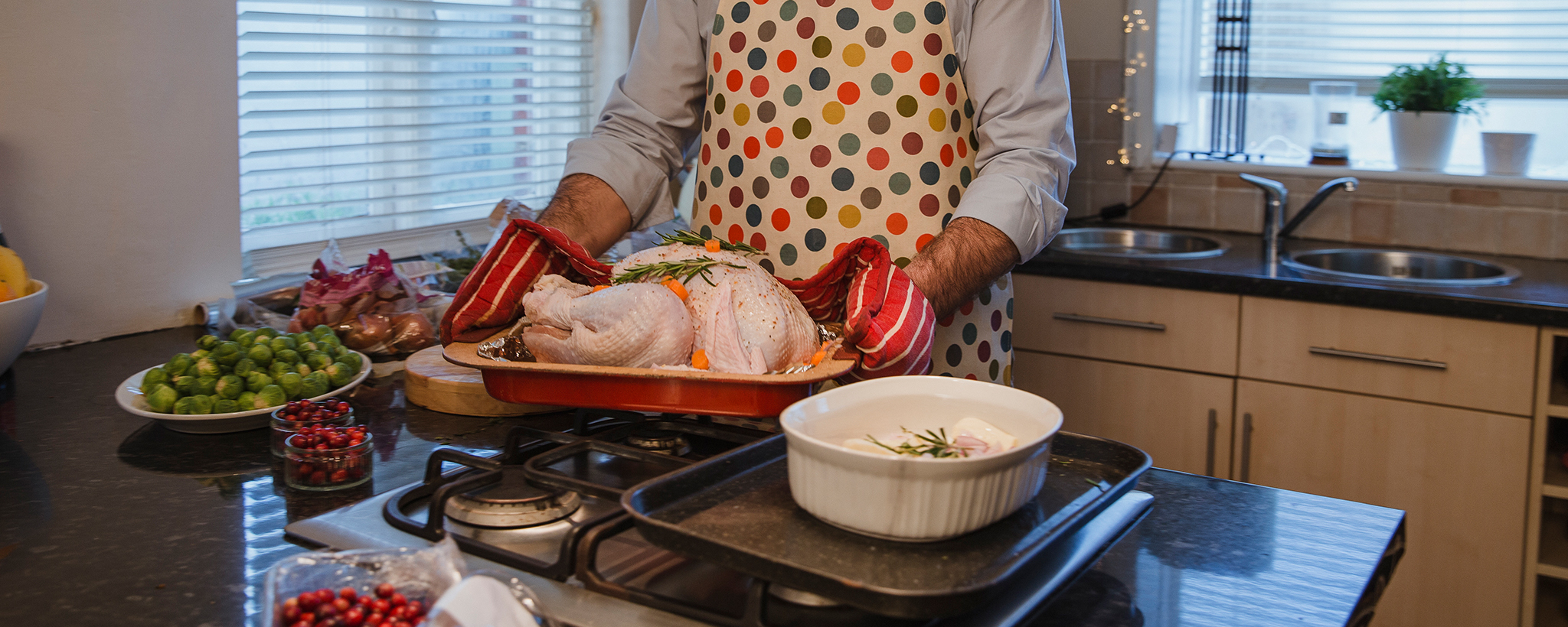 un hombre prepara un pavo navideño para poner en el horno