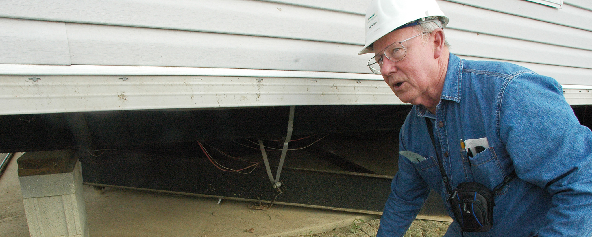 A researcher looking at mobile home tie-downs 
