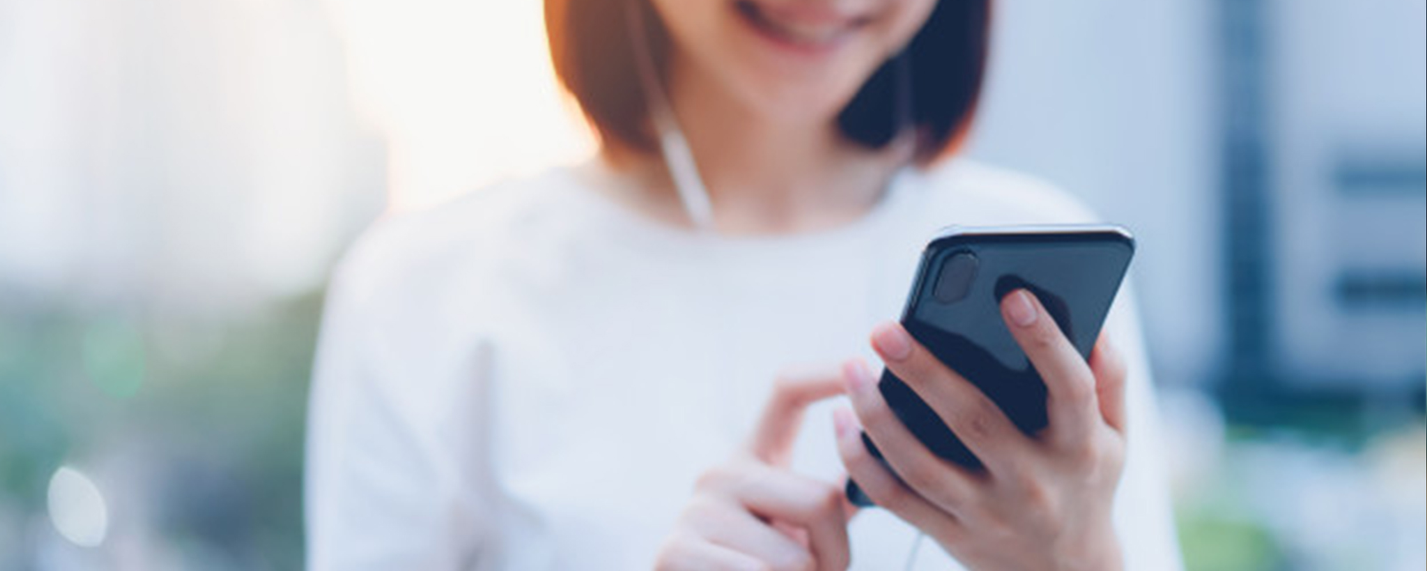 mujer sonriente sosteniendo un teléfono celular