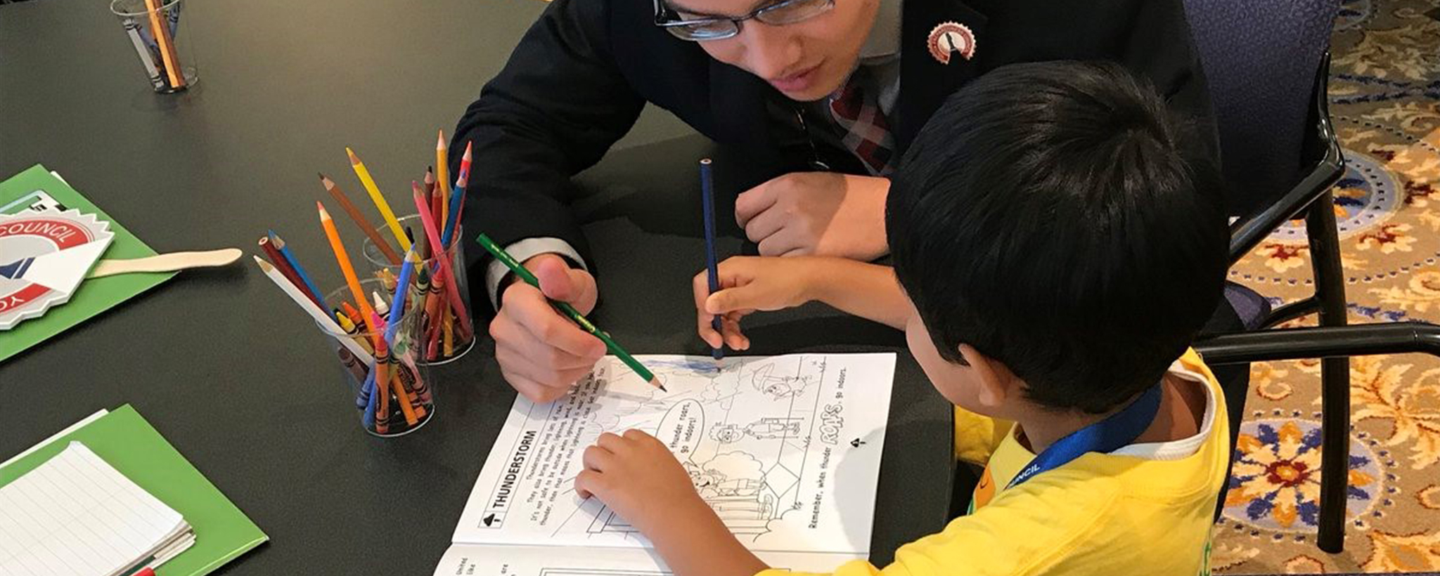 teacher helping a student work on a thunderstorms preparedness worksheet