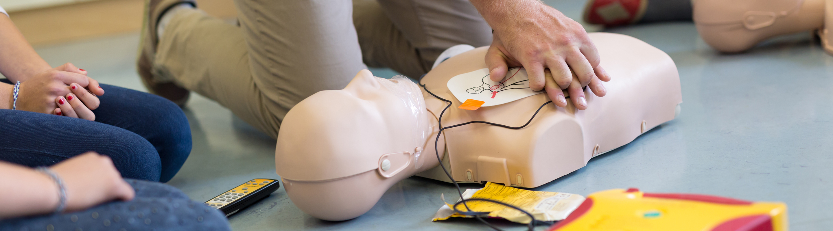 a man practicing CPR life saving skills on a dummy