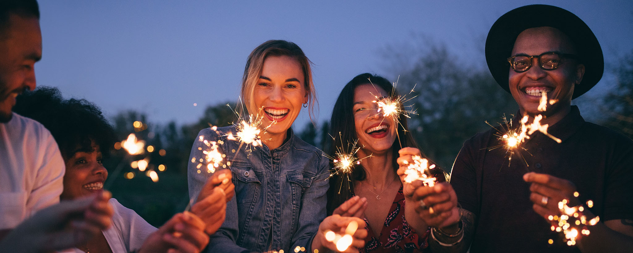 A group of friends holds sparklers 
