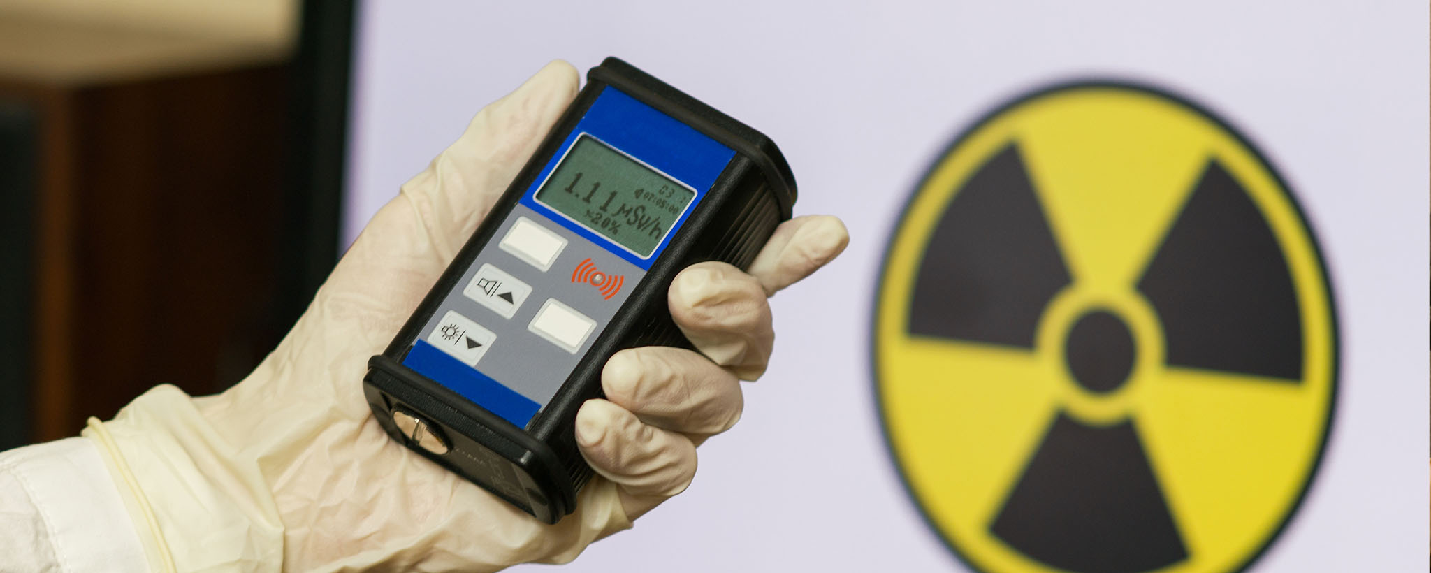 Una mano que sostiene un contador Geiger que mide la exposición a la radiación