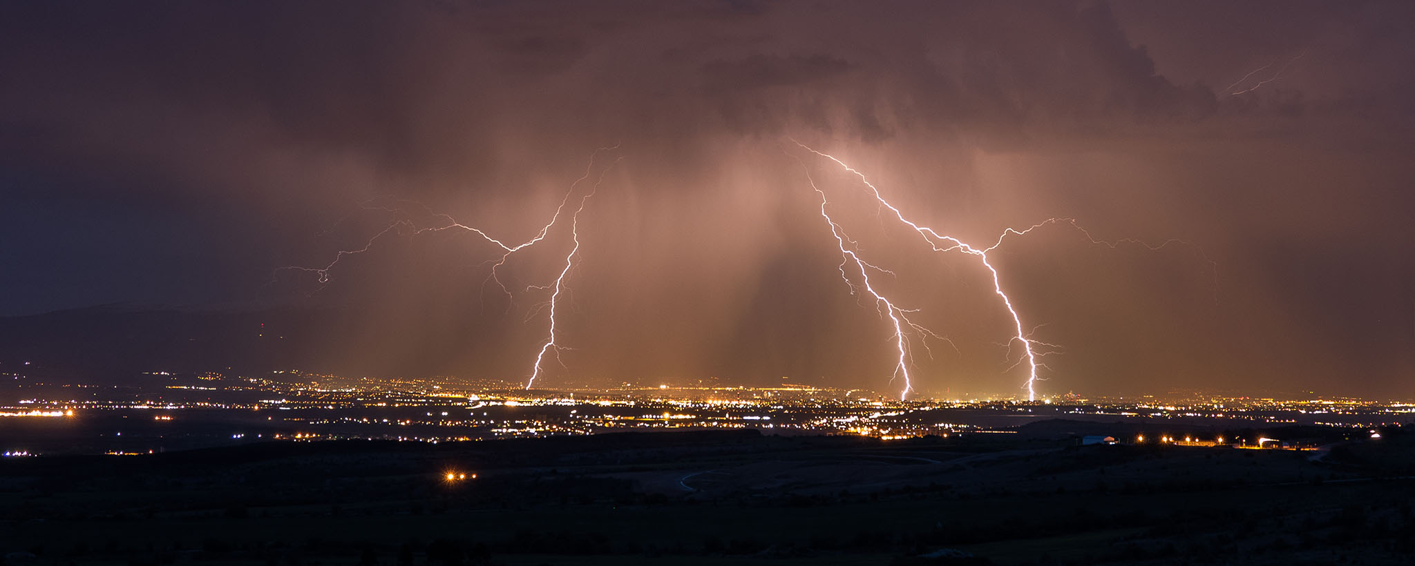lightning striking a city in several places, as seen from afar