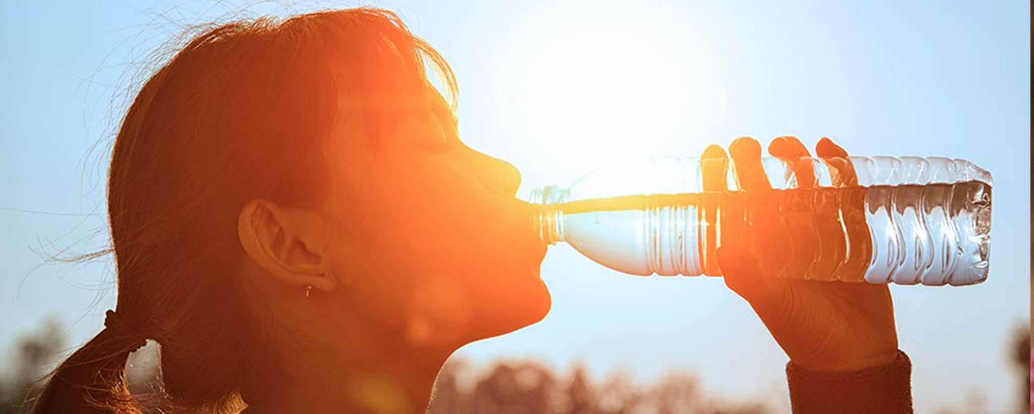 a woman drinking water in the heat