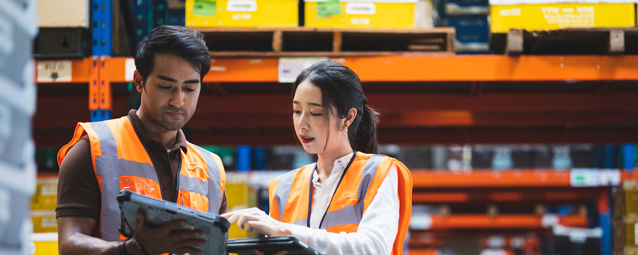 man and woman training with tablets and safety vests