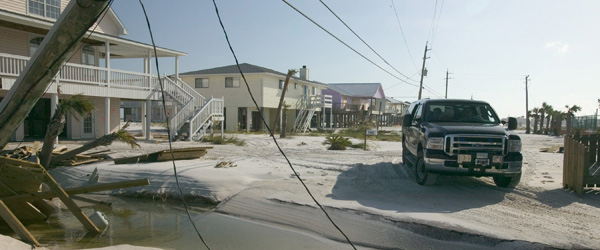 A vehicle on a washed out road encounters a downed power line. 