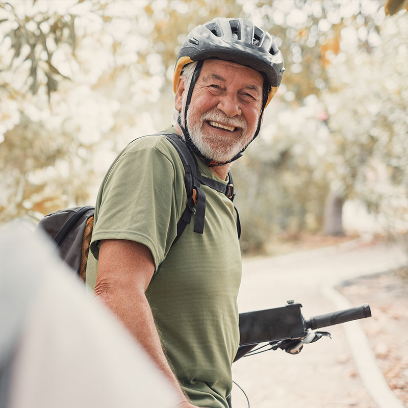Older man on bike wearing a helmet. 