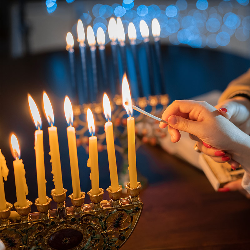 Hand lighting Hannukah candles