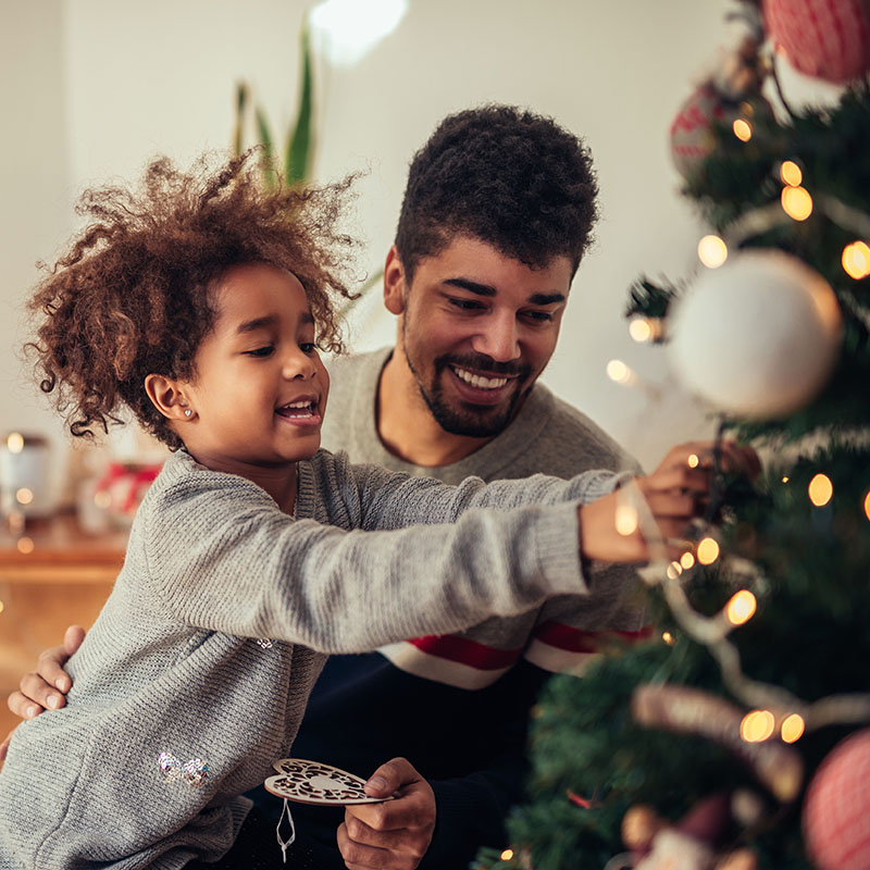 Father and daughter decorating a Christmas Tree