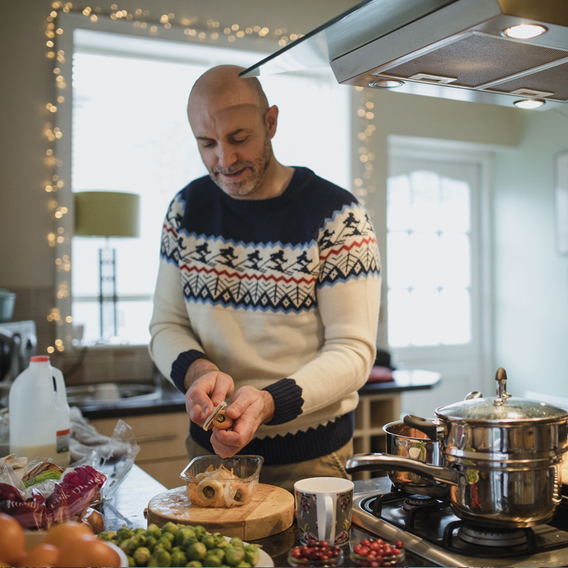 un hombre cocina una comida navideña