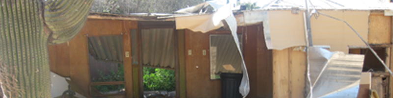 January 18th, 2010. Common household items, such as: blankets, drywall and windows, are scattered outside a destroyed home.