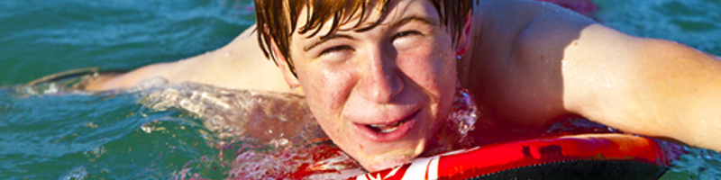 August 15th, 1992. A young beach-goer paddles out on a body board looking to catch a wave back into shore.