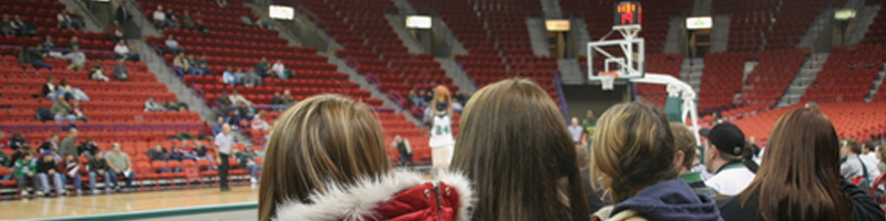 January 27th, 2009. A small group of college girls sit floor-side watching their school run through pre-game warm-ups.