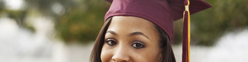 May 21st, 2011. A young woman poses for a post-graduation picture sporting a burgundy robe and cap.