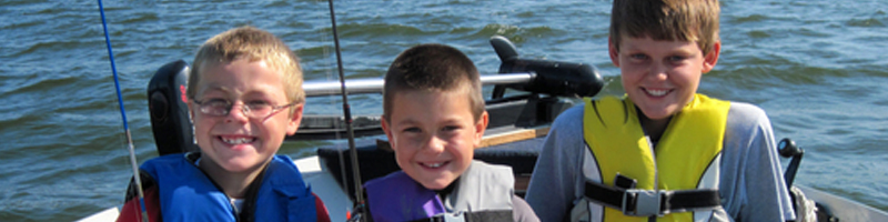 May 29th, 1998. Three boys smiling on a boat while wearing their life vests. May 29th, 1998. Three boys smiling on a boat while wearing their life vests.