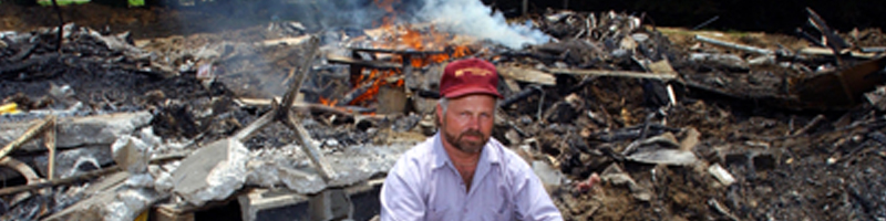 June 16th, 2003. A man sits on top a pile of debris. June 16th, 2003. A man sits on top a pile of debris.