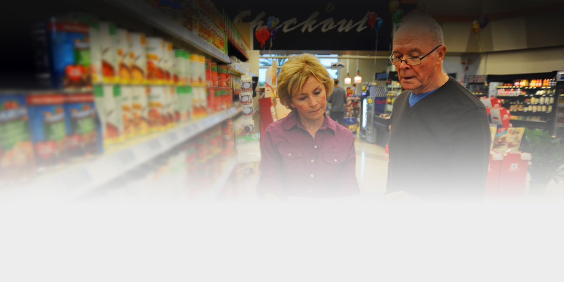 Picture of two seniors shopping in the grocery store from a list.