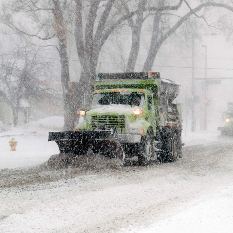 a plow clears the road during a snowstorm