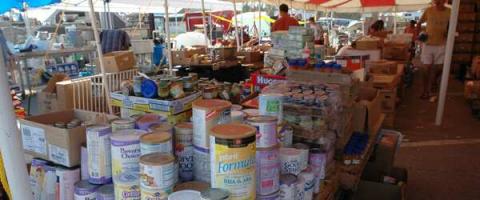Volunteers organize donated non-perishable items including infant formula and diapers.