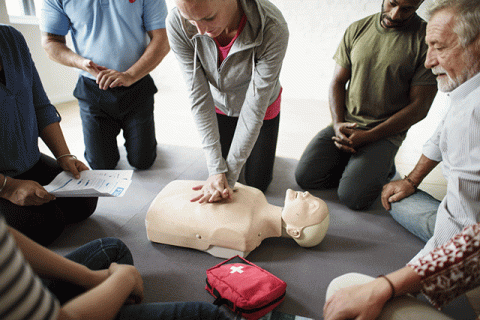 An instructor demonstrating CPR on a dummy