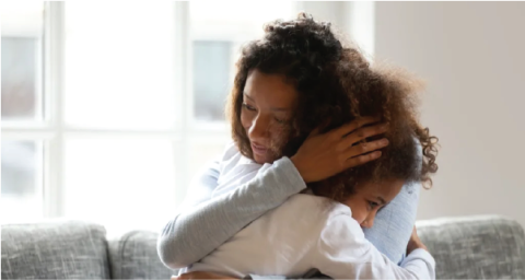 Mother hugging daughter