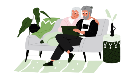 older adult couple sitting on a couch looking at a laptop