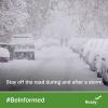 cars parked along a road under heavy snow