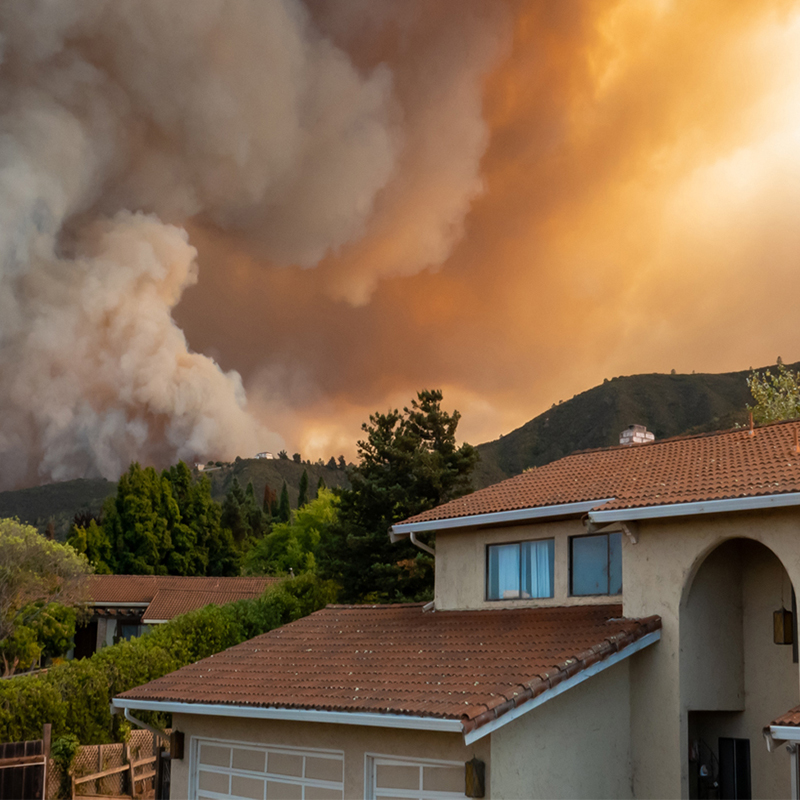 Humo de un incendio forestal en el fondo de una casa. 